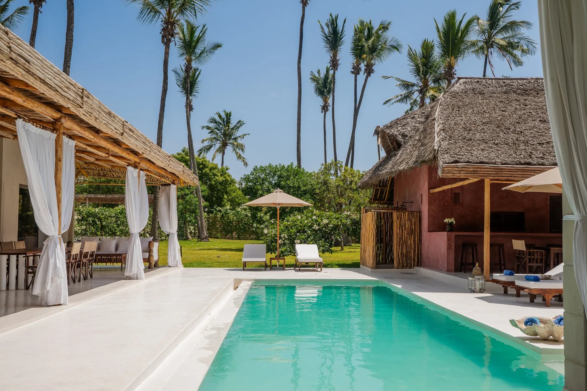 Tropical villa complex with palm trees, pool, and lush greenery