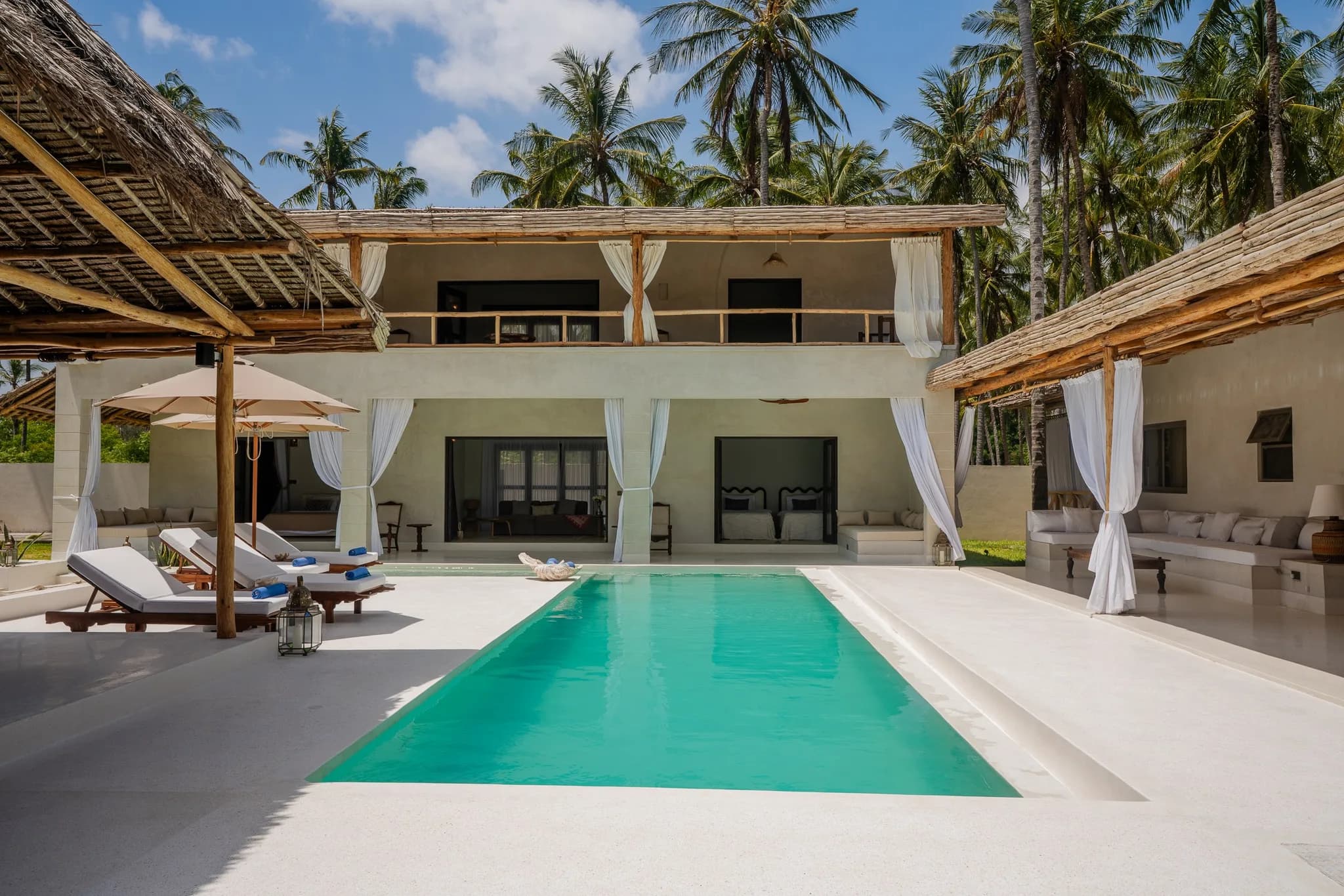 Luxury tropical villa with turquoise infinity pool and palm trees