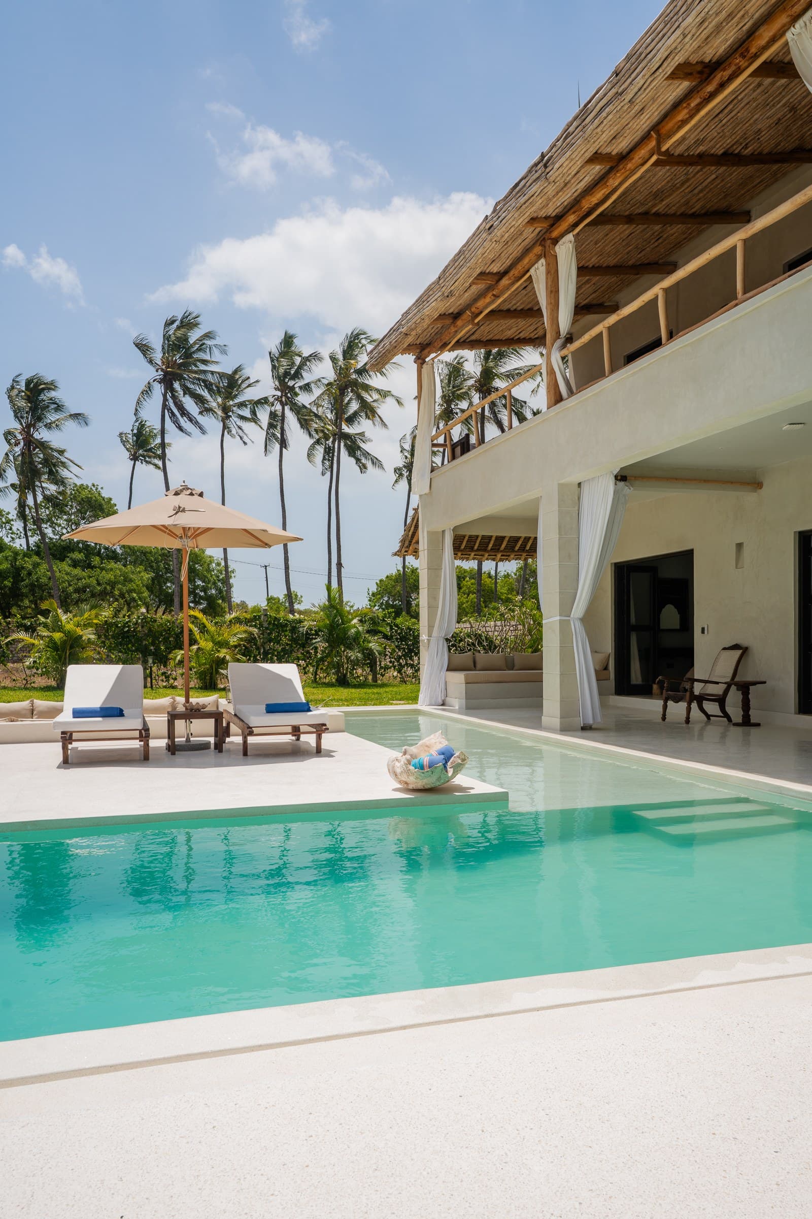 Modern living room with sofa, coffee table, and pool view