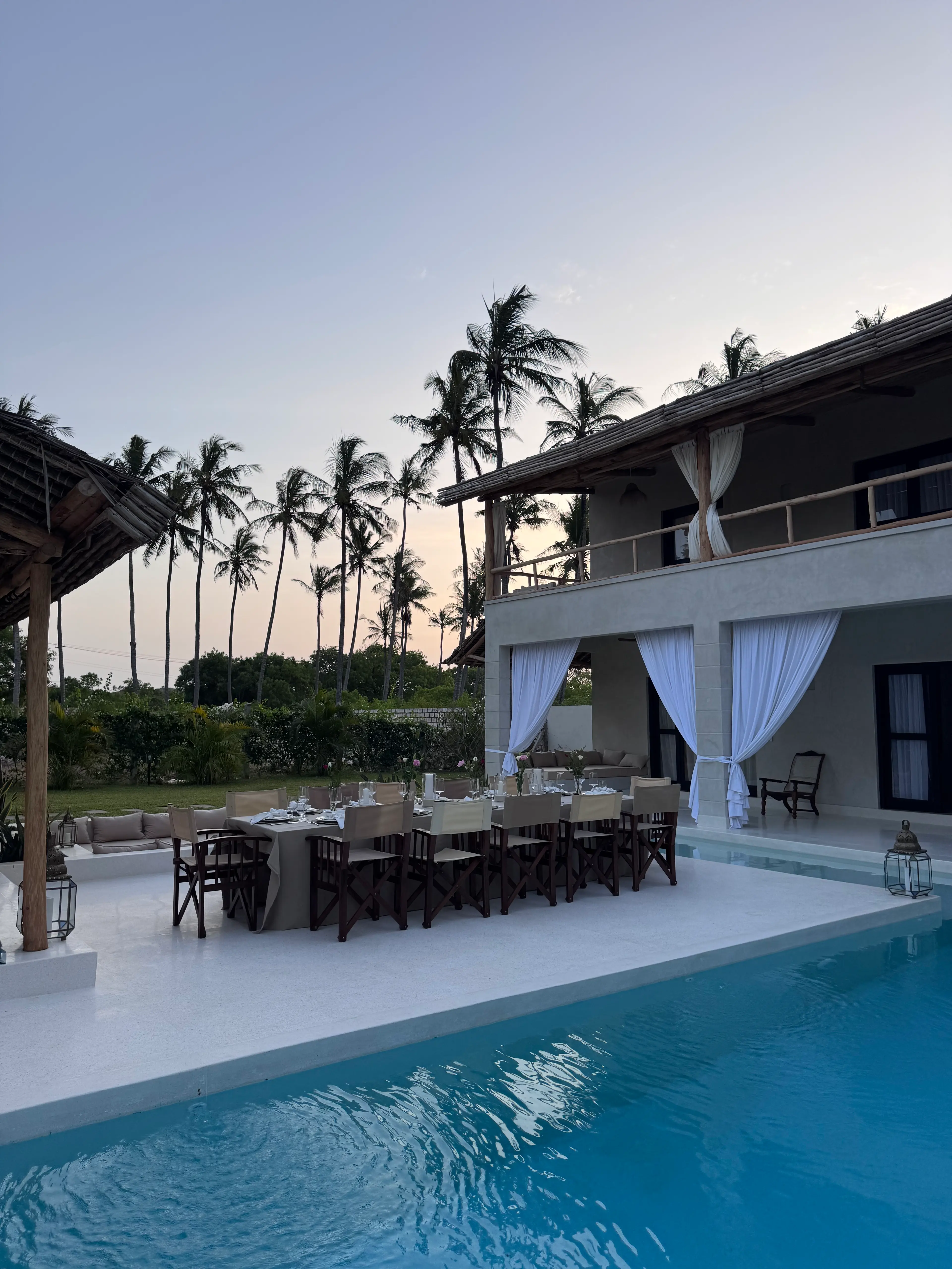 Aerial view of multi-level tropical resort with central pool and lounges